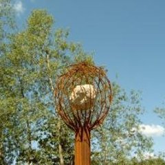 Skulptur aus Metall geformter Baum mit Stein in der Krone