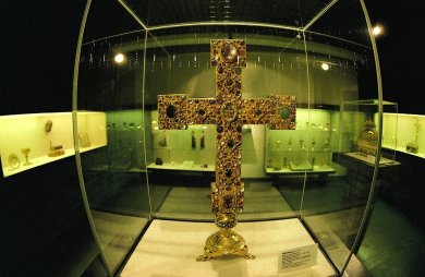 Goldenes Kreuz in Glasvitrine aus Sicherheitsglas
