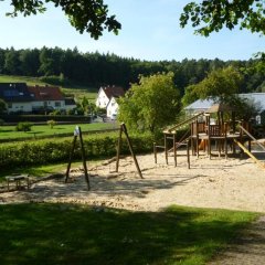 Spielplatzgelände mit Rutsche und Kletterturm
